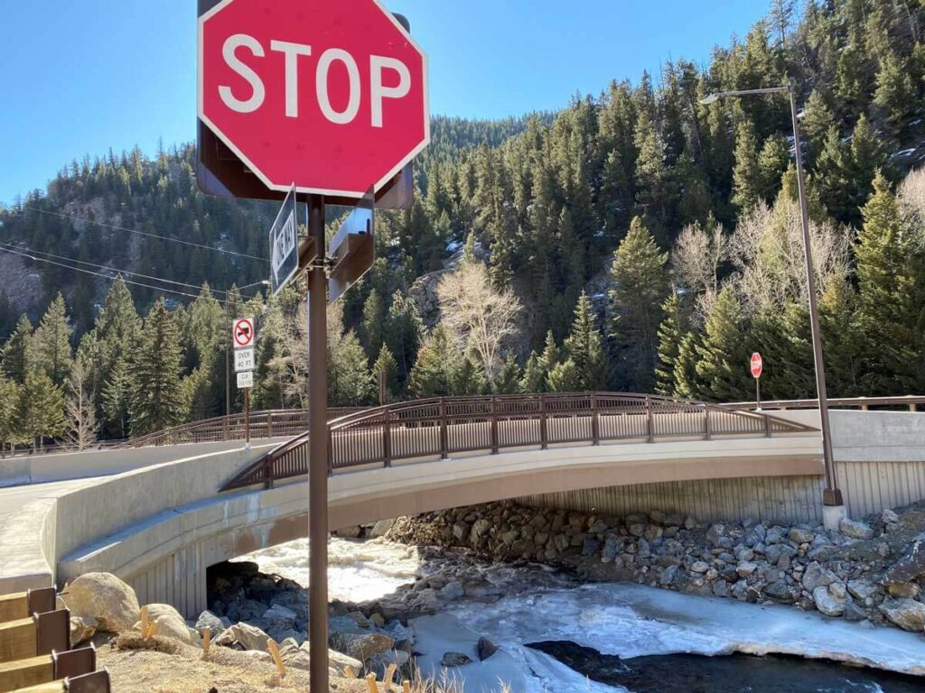 stop sign near bridge over water