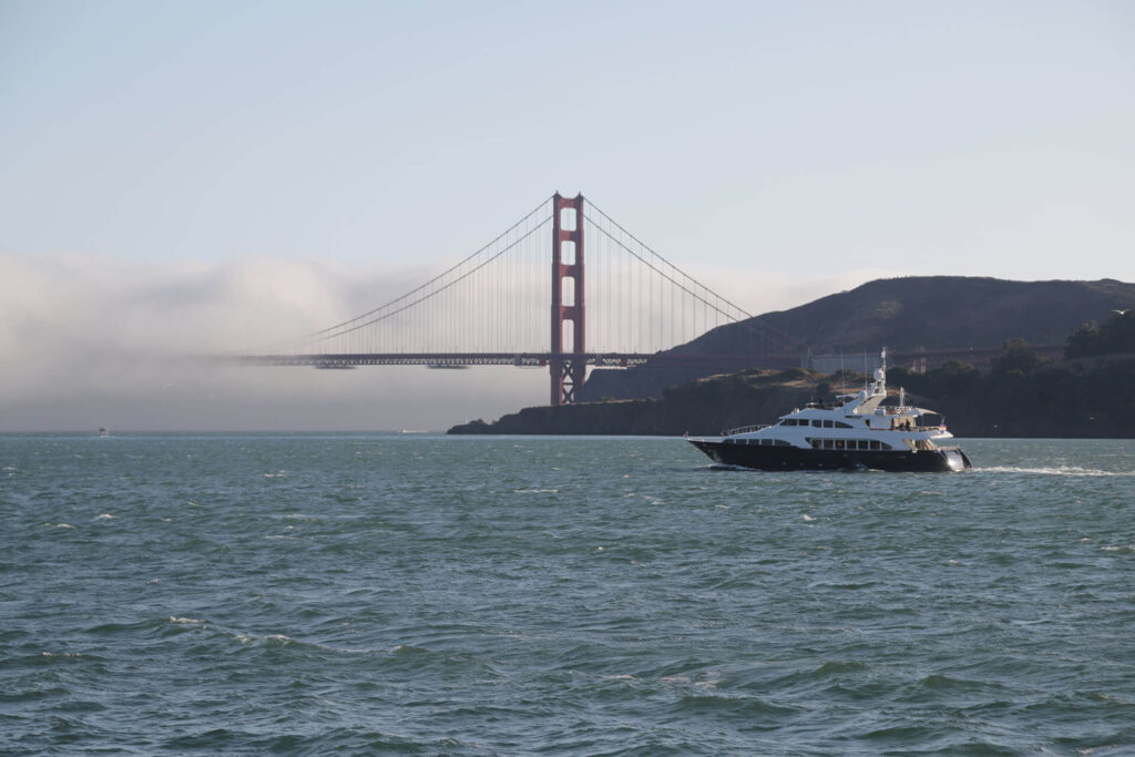 boat navigating through the bay area of San Francisco with the Golden Gate Bridge in the background