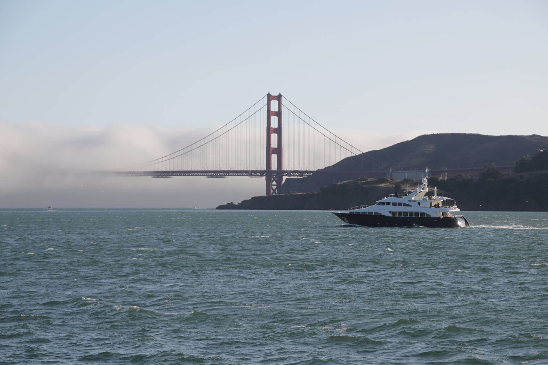 boat navigating through the bay area of San Francisco with the Golden Gate Bridge in the background