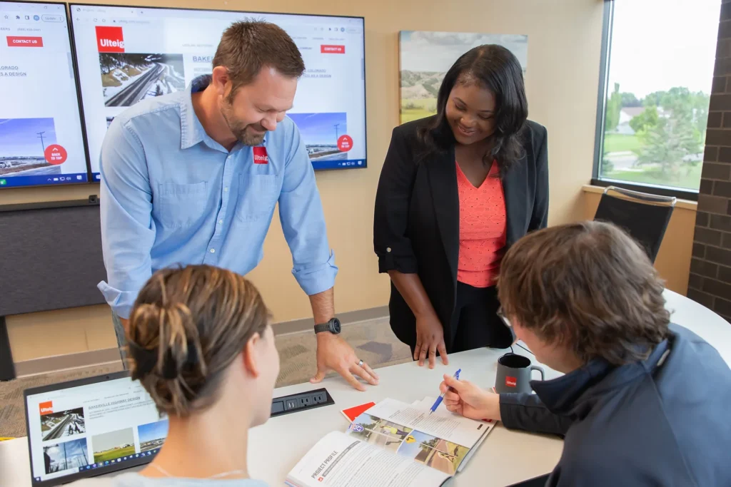 Several people around a table reviewing materials