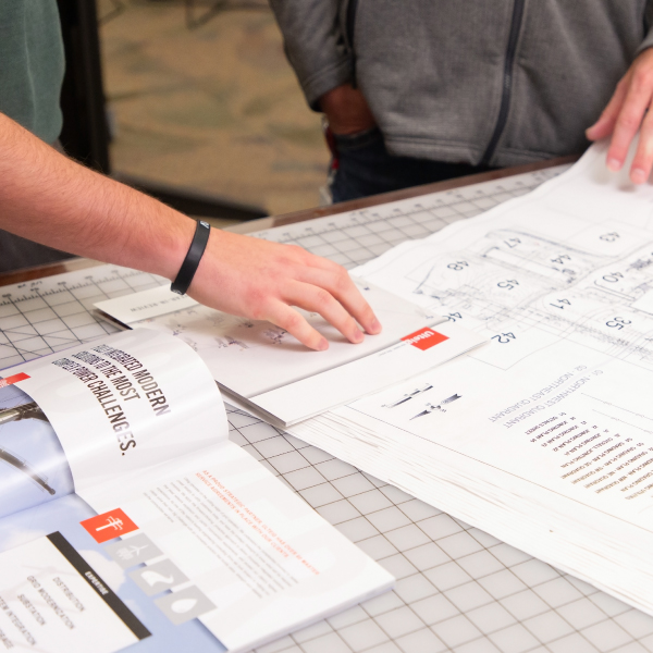 hand pointing to engineering plans