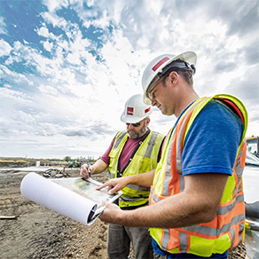 People in safety equipment reviewing plans